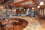 The Chef`s Kitchen features a horseshoe-shaped bar, custom wood work and granite countertops.